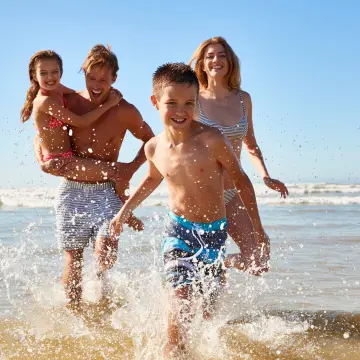 Happy family enjoying a beach day trip near Alicante on a sunny summer morning