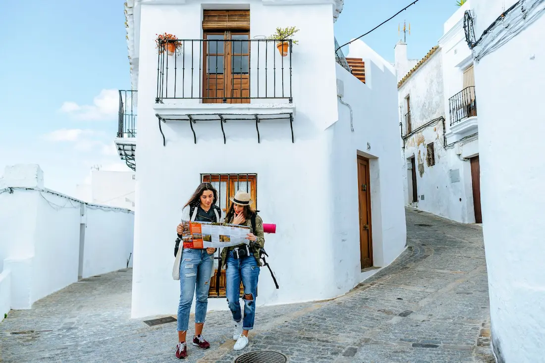 Two women walking through the narrow streets of a picturesque village in Alicante.