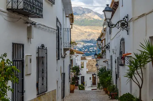 Scenic cobblestone street in Altea old town with whitewashed houses and Mediterranean Sea views