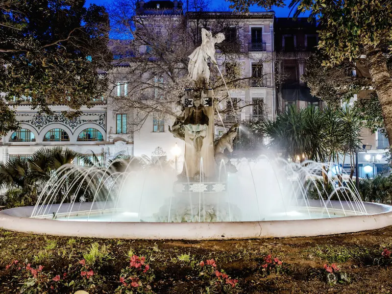Fountain and Art Nouveau buildings at Plaza Gabriel Miró in Alicante at night
